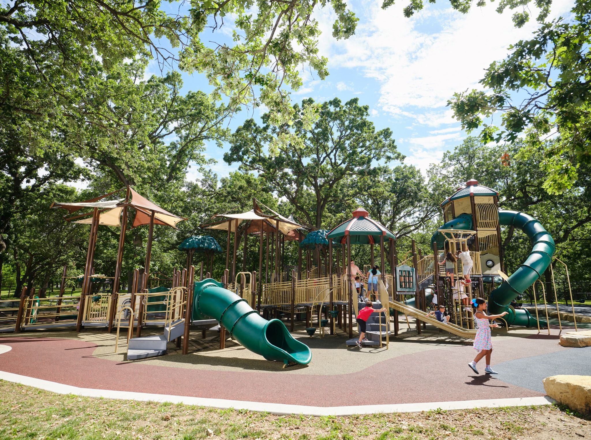 Children using inclusive play equipment at Augsburg Adventure Park