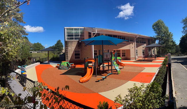 Ground-level view of rubber-surfaced play features at Bates Elementary School