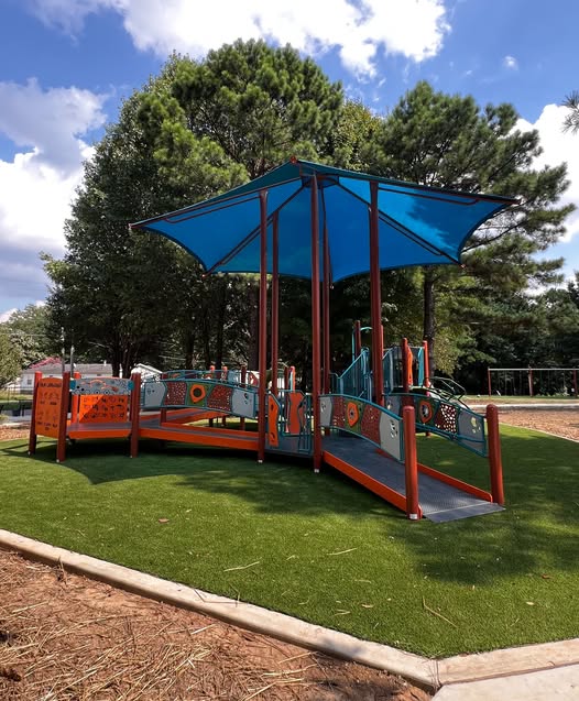 Inclusive playground area with shade at Eva B. Barber Park