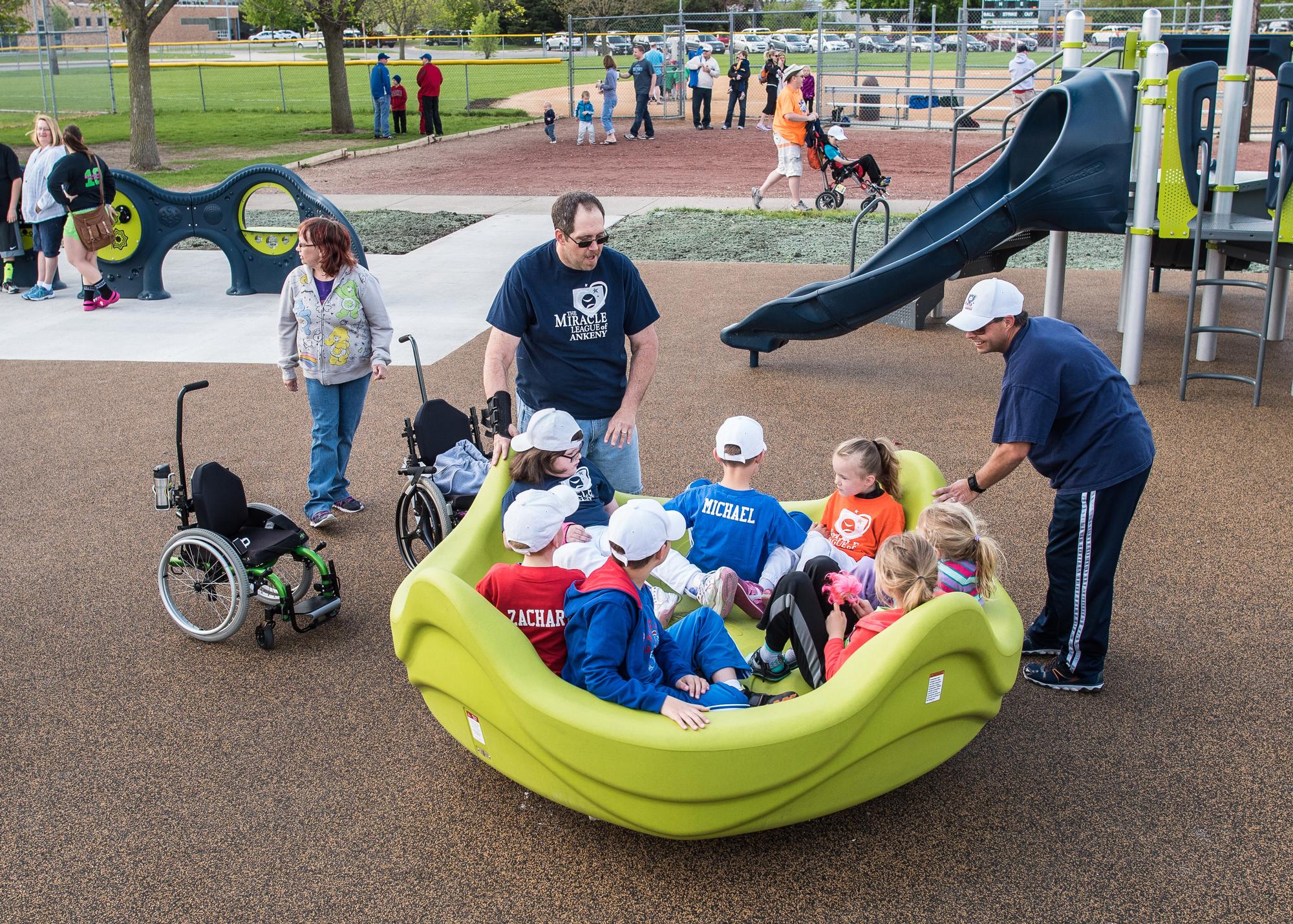 Children using an adaptive merry-go-round