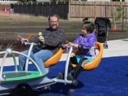 Child and adult using the inclusive play structure at Jay Pearson Neighborhood Park
