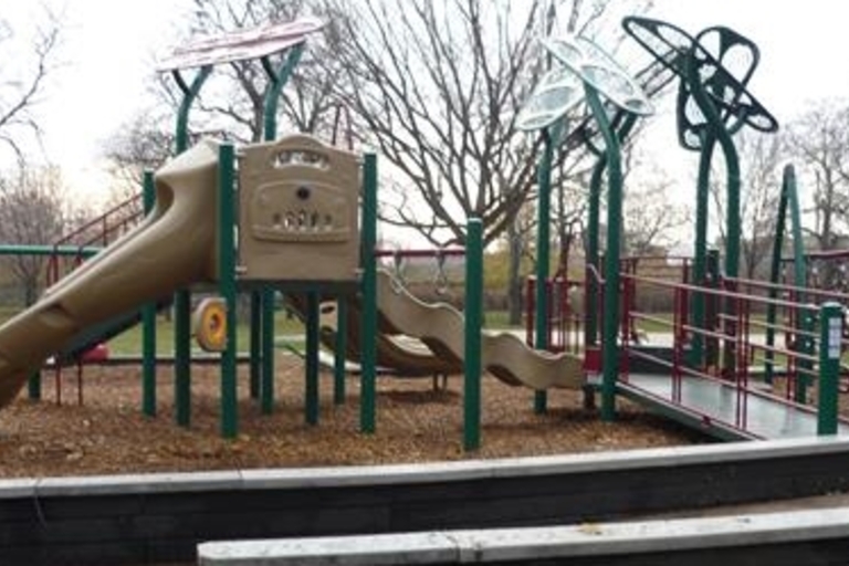 Playground at John Levin Park with accessible slides and climbing features.