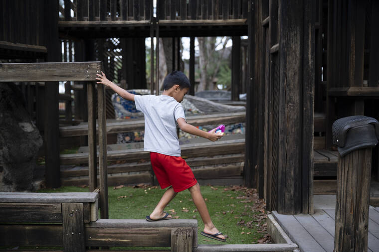 Child playing at Kamalani Playground at Lydgate Park