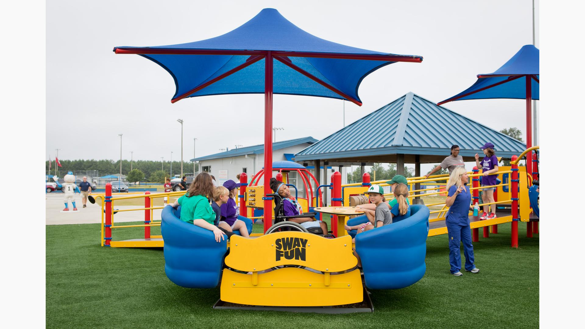 Children playing on inclusive equipment at Miracle League of Monticello
