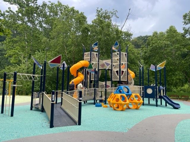 Colorful playground with ramps, nets, and slides at Pinecliff Park