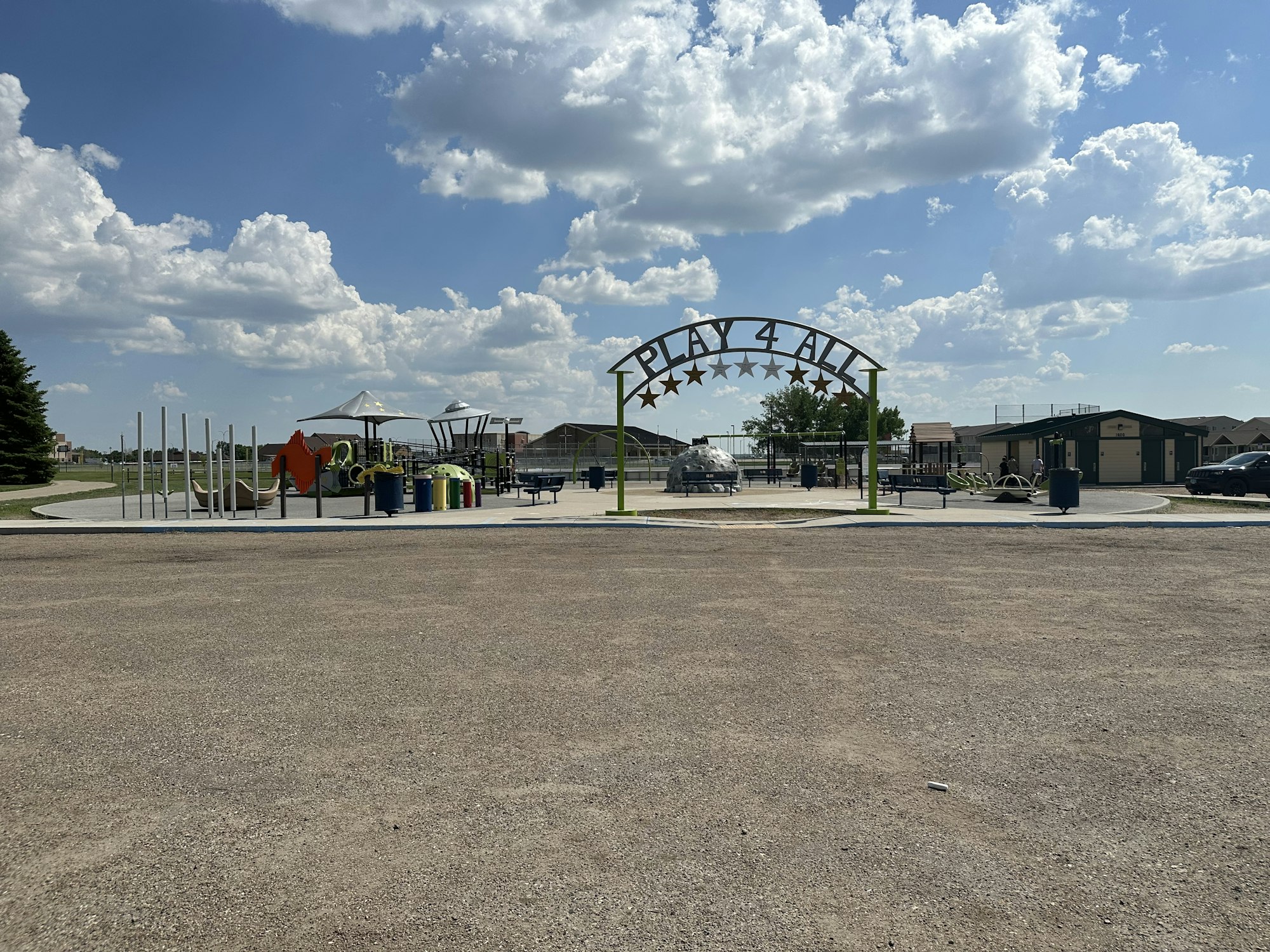 Front view of Play 4 All playground with accessible entry arch and play structures