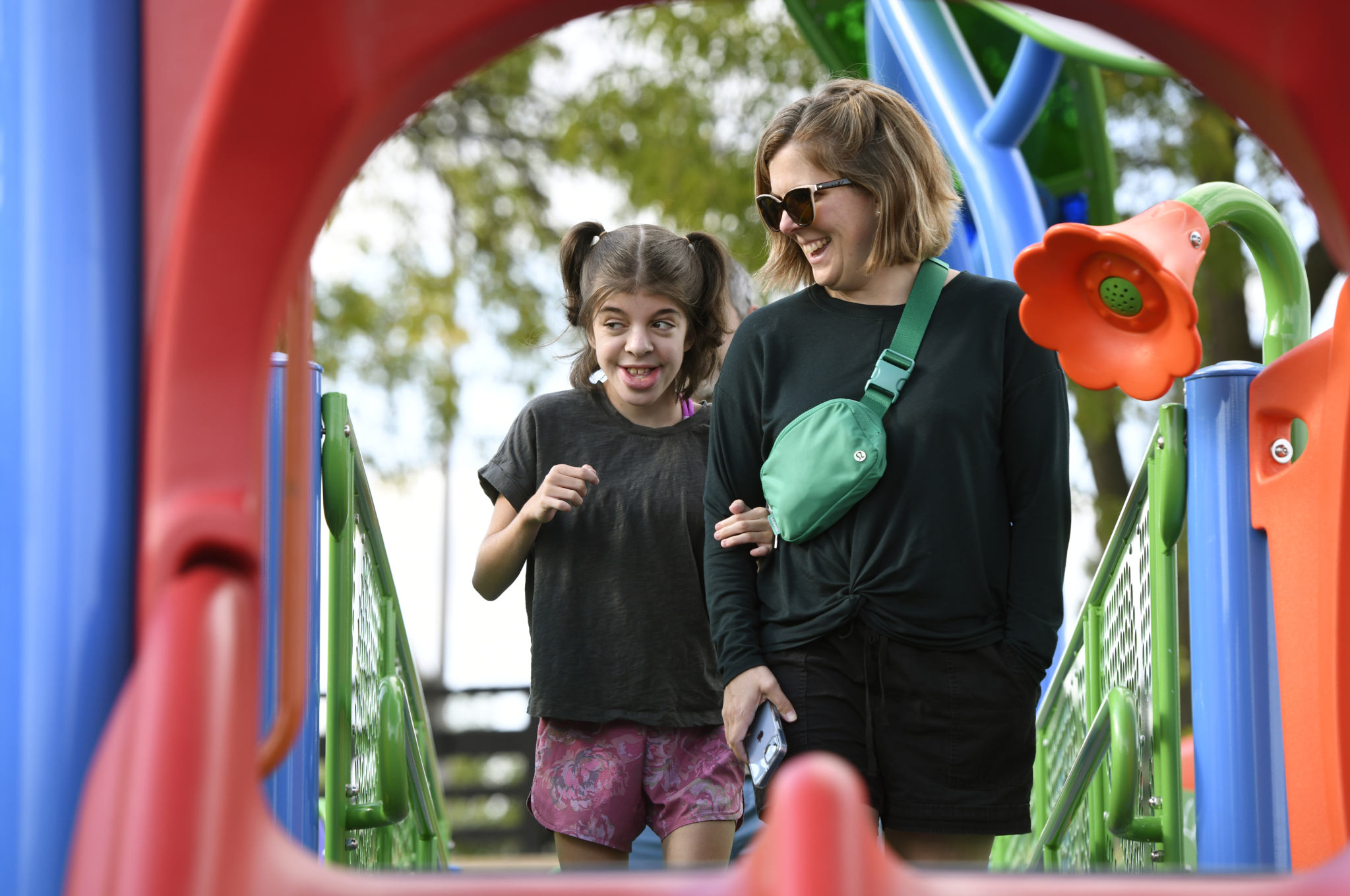 Children and adults using Play Michigan playground features