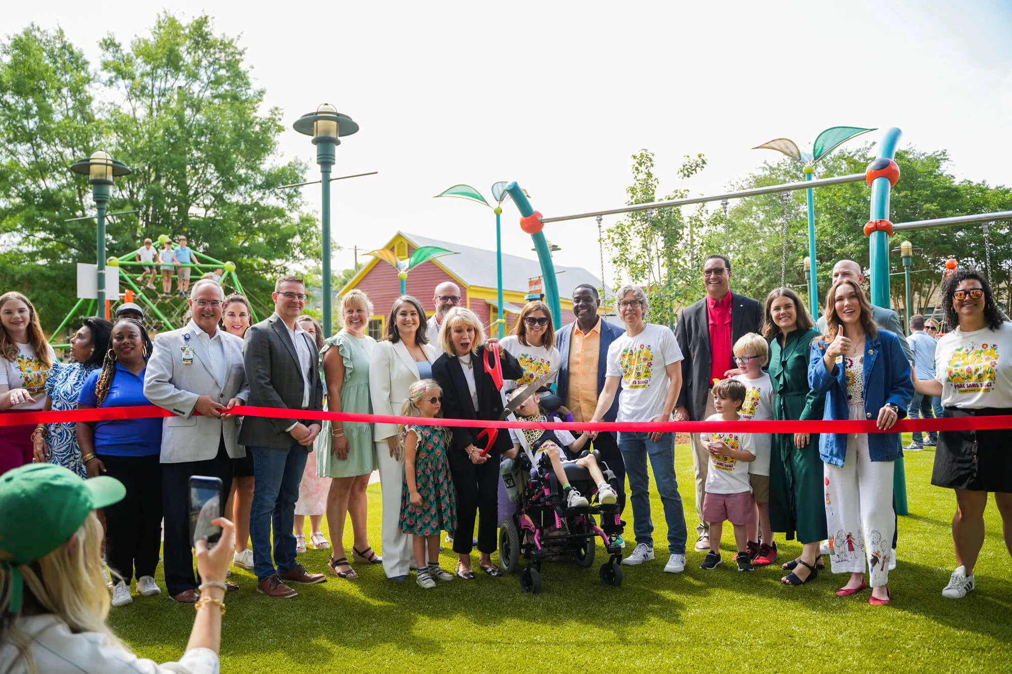 Ribbon cutting crowd at the Playground at Parc Sans Souci