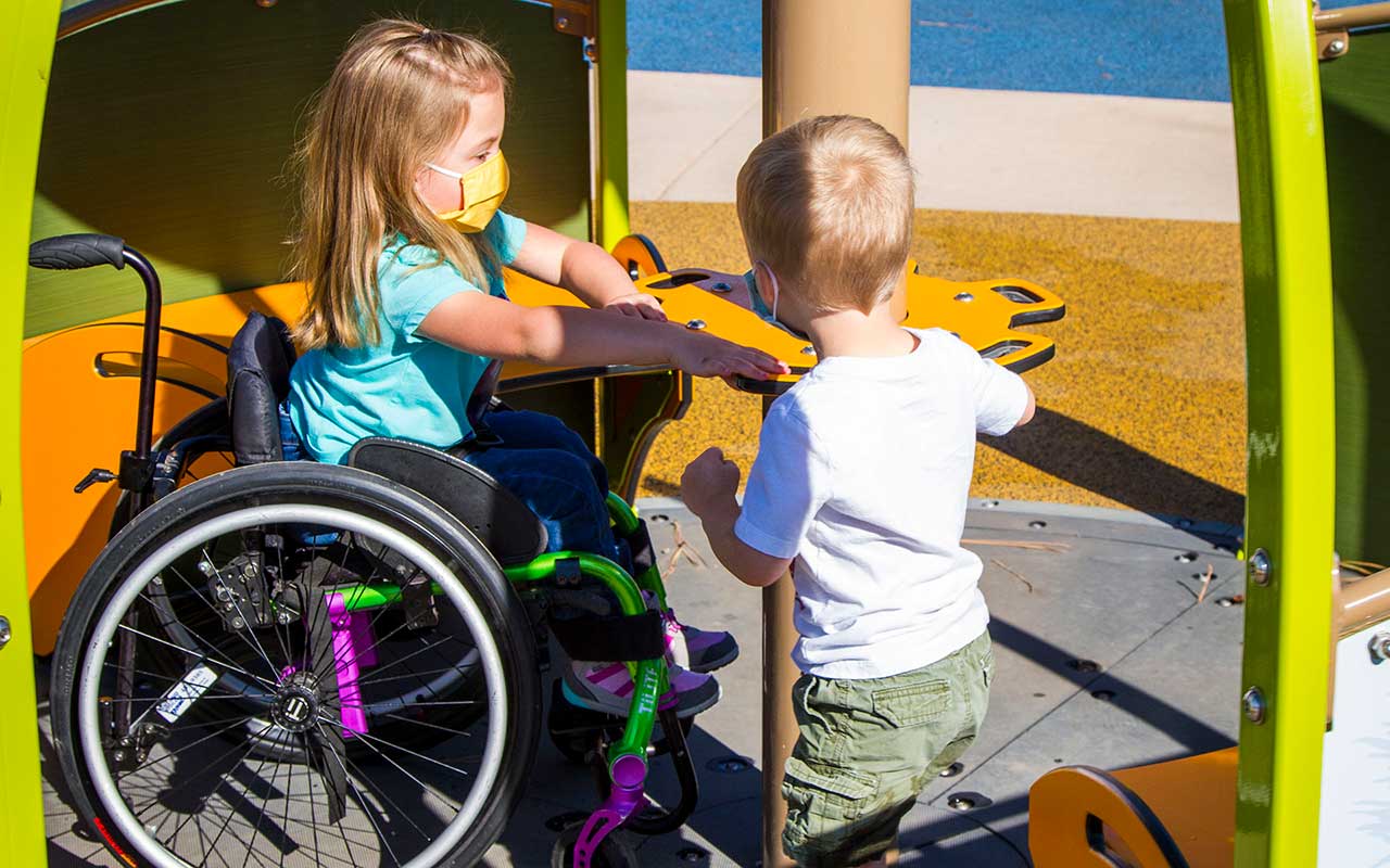Children using inclusive play equipment at Providence Playscape