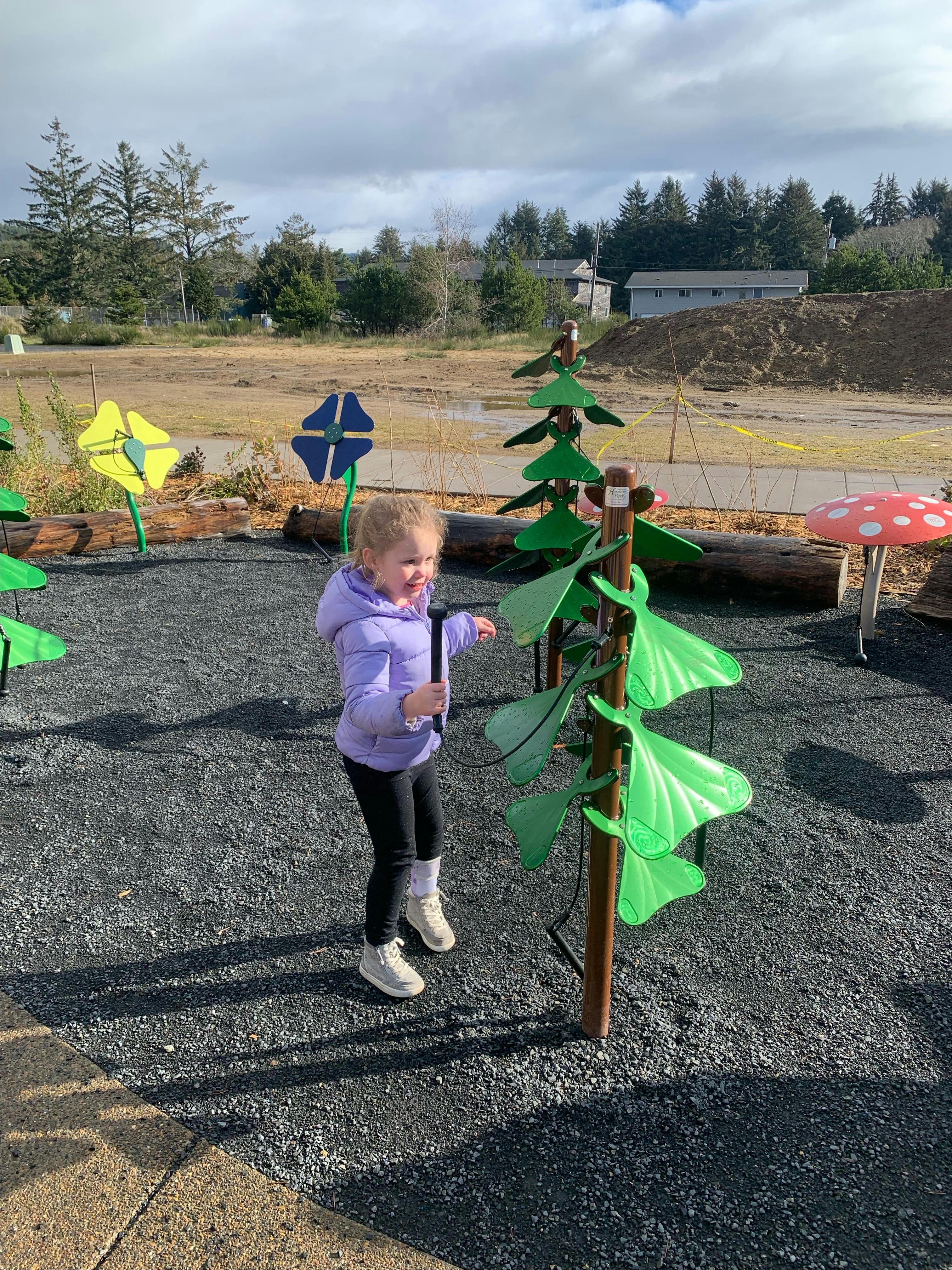 Child playing musical instruments at Schooner Creek Discovery Park