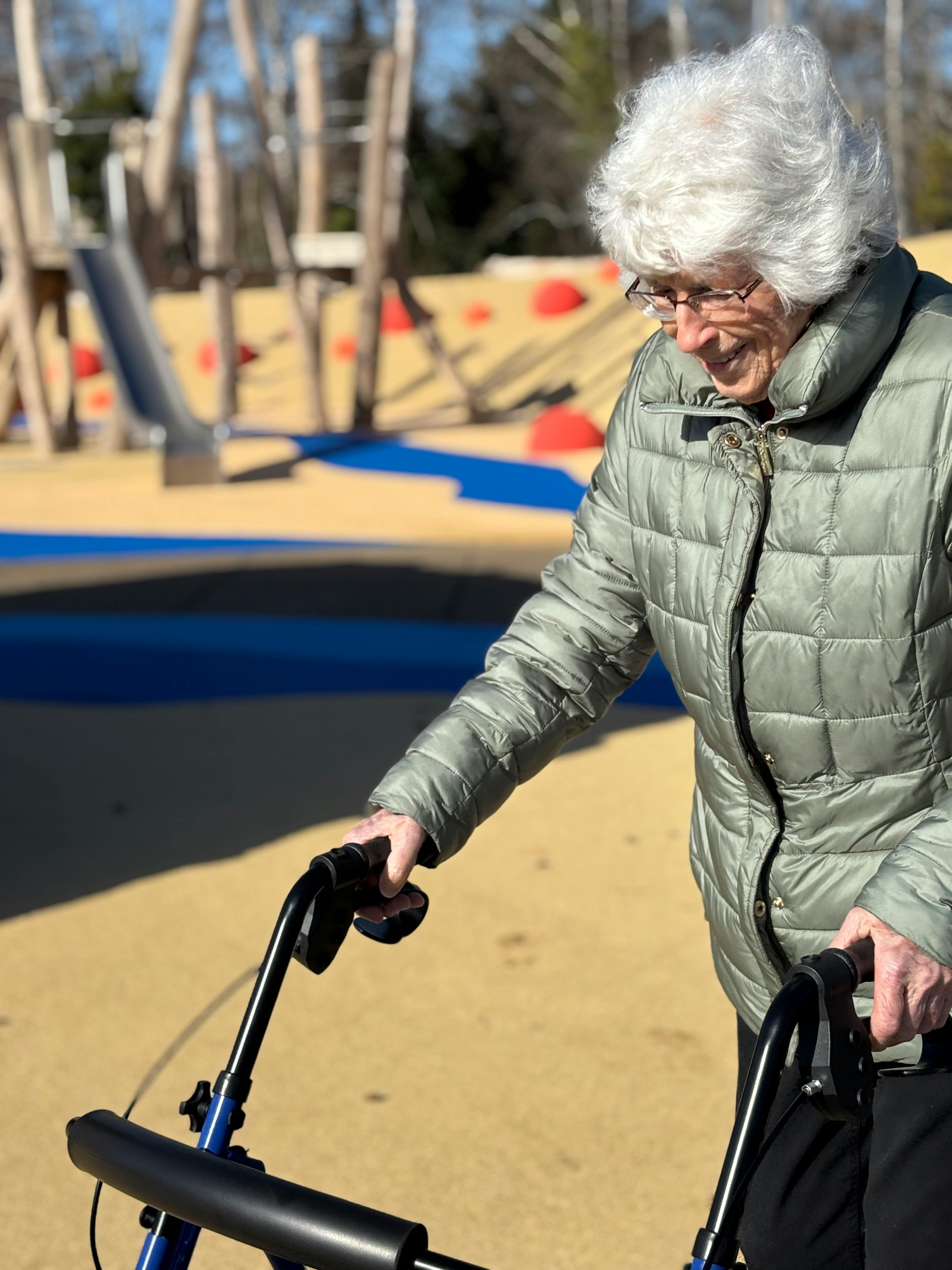 Visitor using the accessible playground surface at Schooner Creek Discovery Park