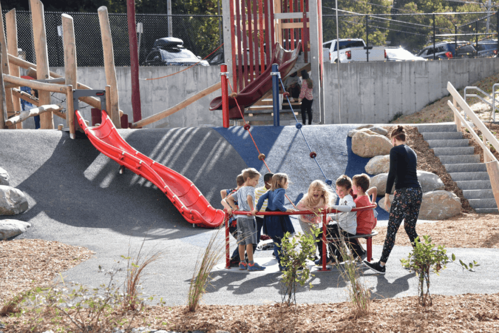 Children playing together on the Accessible Whirl at St. Johnsbury School