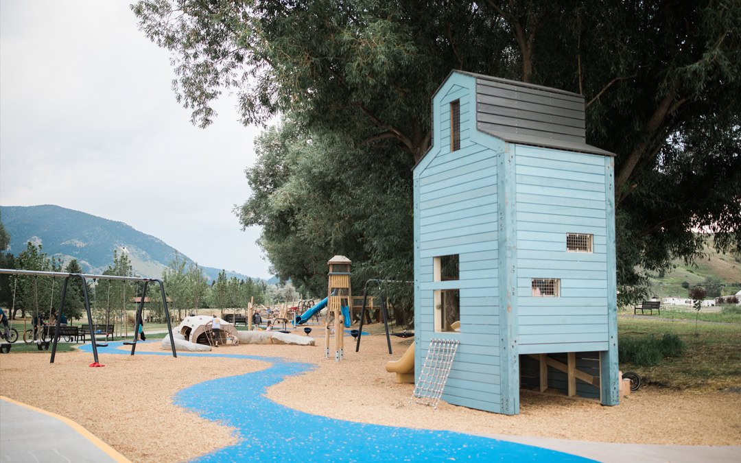Main Story Mill playground area with blue tower, swings, and surrounding trees