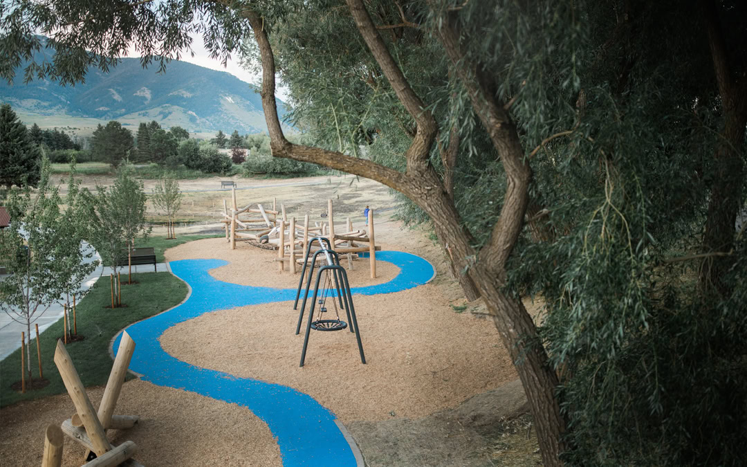 Story Mill playground with accessible path winding past natural climbing features