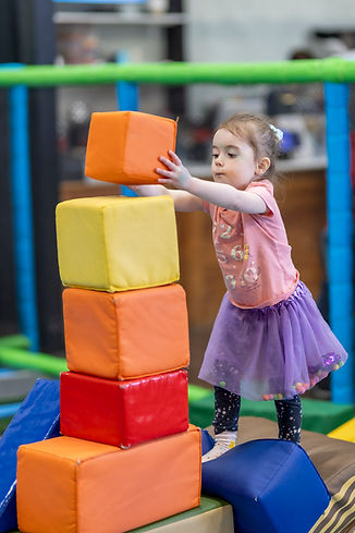 Toddler stacking large foam blocks at Ahoy Kitsap Playland