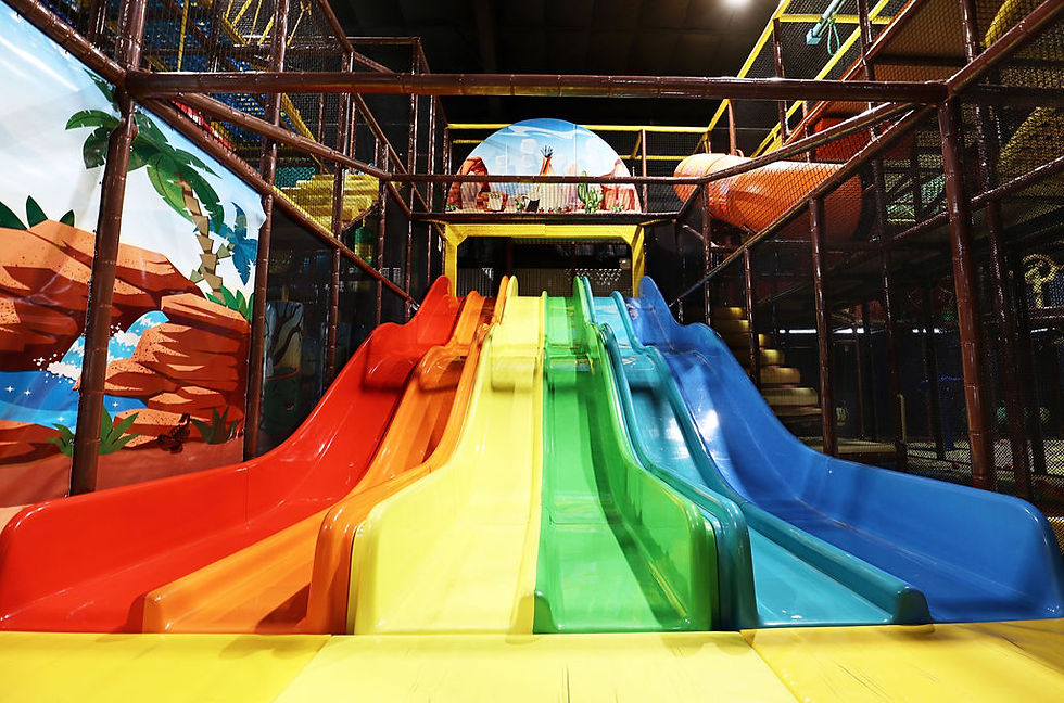 Large indoor climbing structure with slides at Arrows Active Play Park