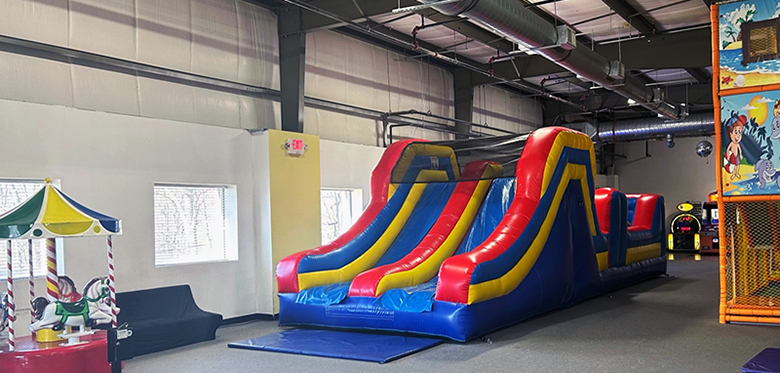 Large inflatable slide and open play floor at BB Kidz Klub.