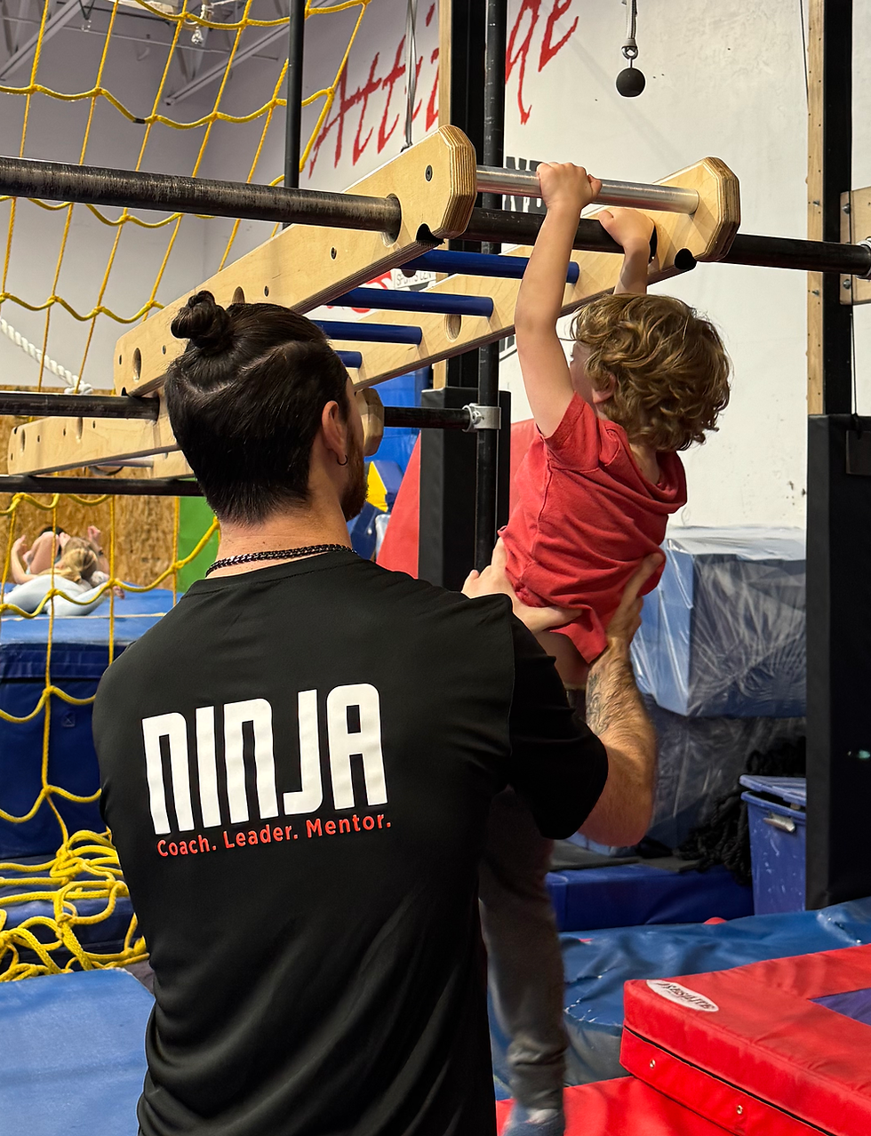 Young child working on ninja obstacles with a coach at Black Diamond Park City.