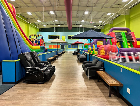 Parent seating area beside the inflatable attractions at Bounce Hopper.