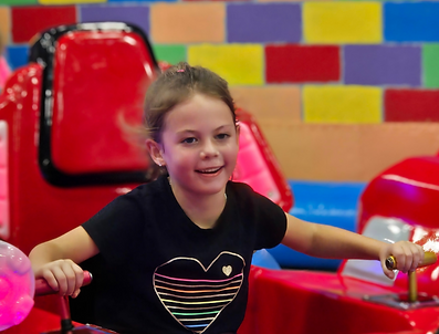 Child riding bumper-car style attraction at Bounce Xtreme