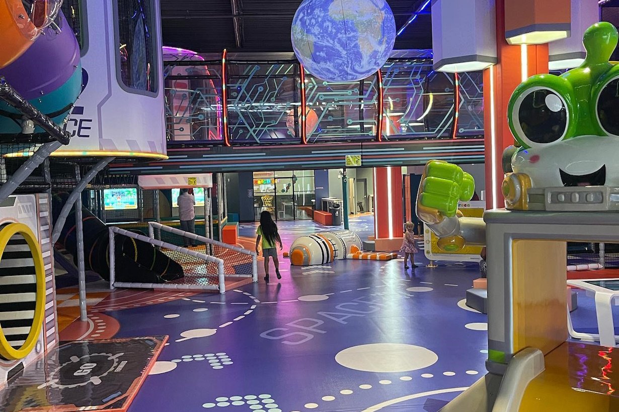 Open play floor with space-themed structures at Catch Air Jersey City.