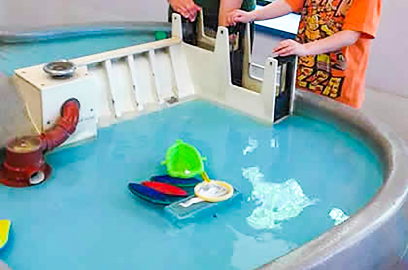 Children using the museum's river water table exhibit.