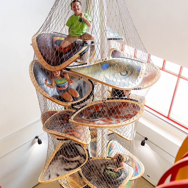 Children climbing inside the Luckey Climber net structure at the Children's Museum of La Crosse.