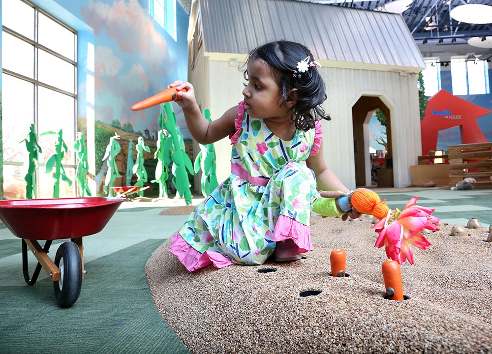 Young child playing in the Prairie Farm exhibit at the Children's Museum of South Dakota.
