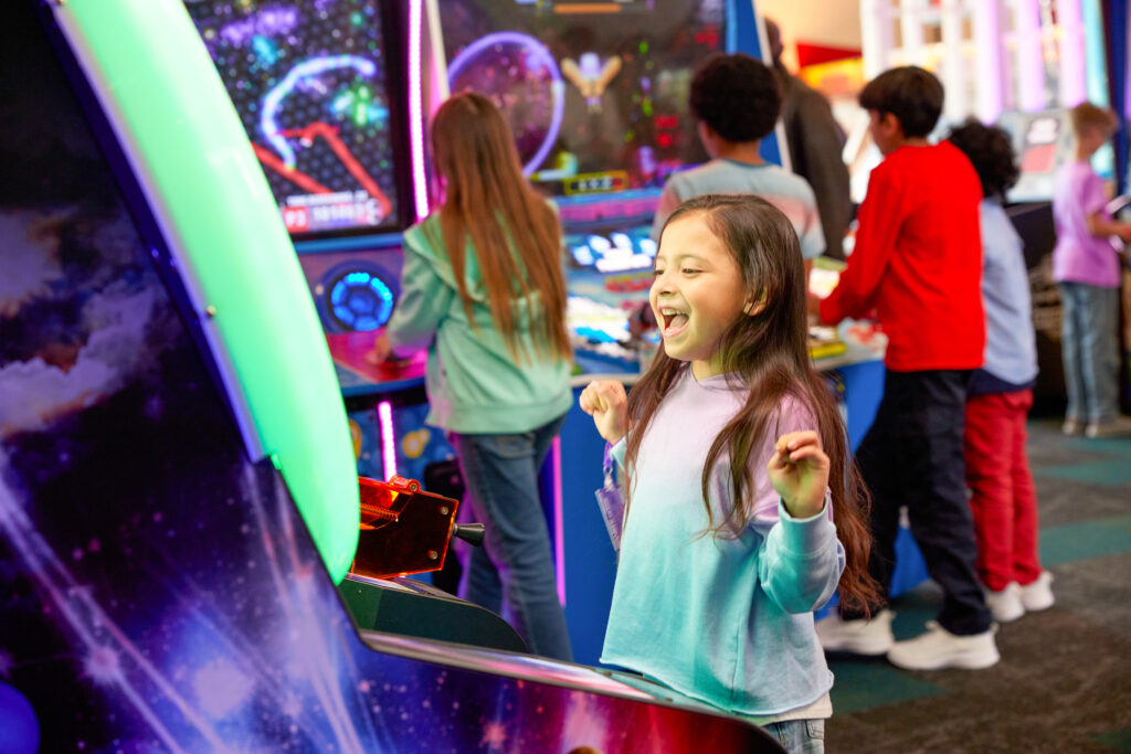 Kids playing arcade games at Chuck E. Cheese.