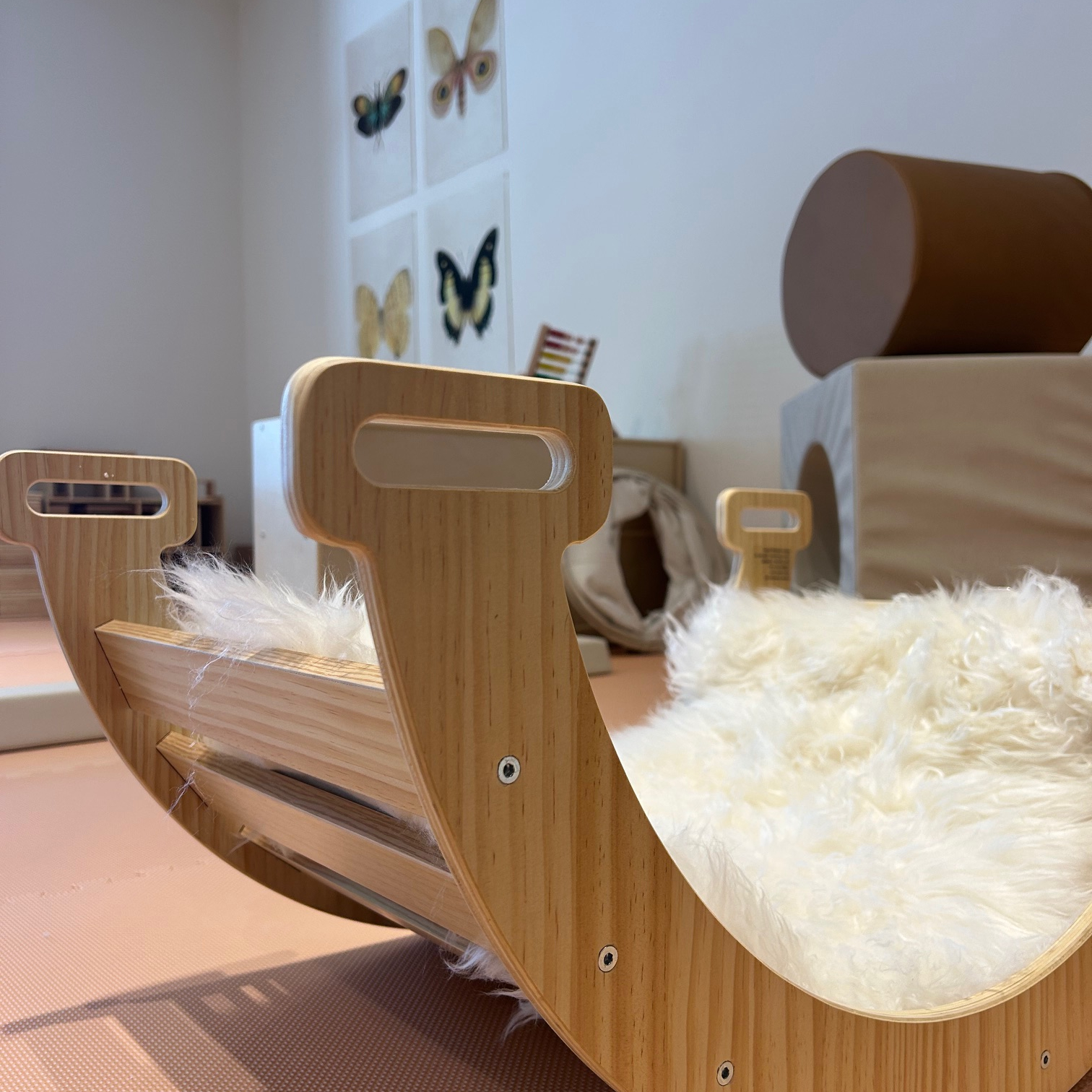 A wooden rocking play piece inside Cocoon Hailey.