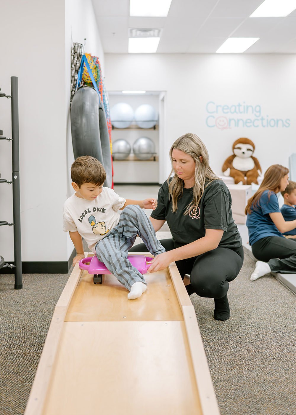 Caregiver and child using a play element at Creating Connections.