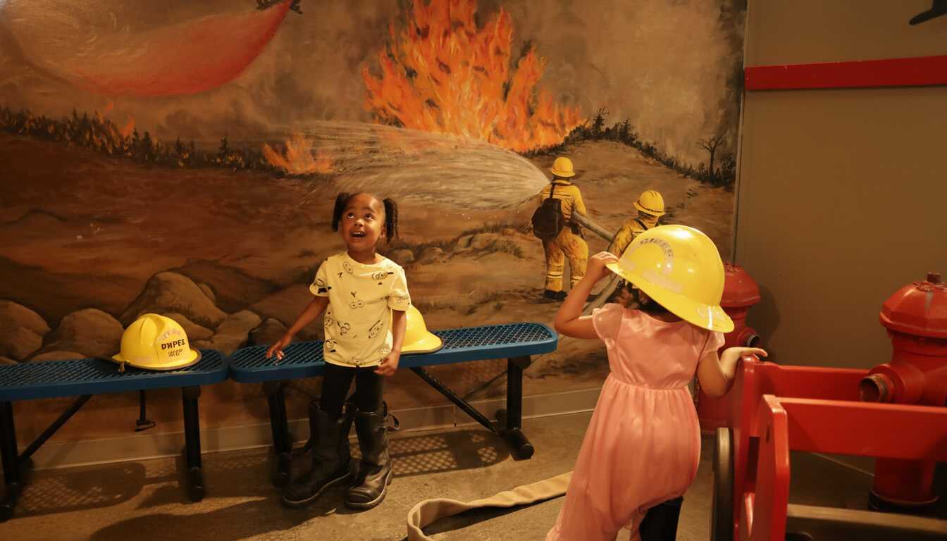 Kids dressing up and playing in the fire station exhibit at CRR Discovery Museum.
