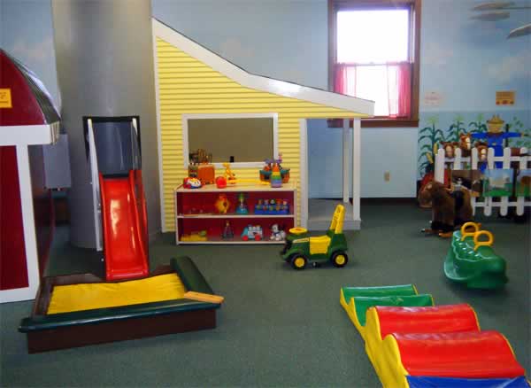Toddle Farm toddler play room inside Curious Kids' Museum with a slide and farm-themed play features.