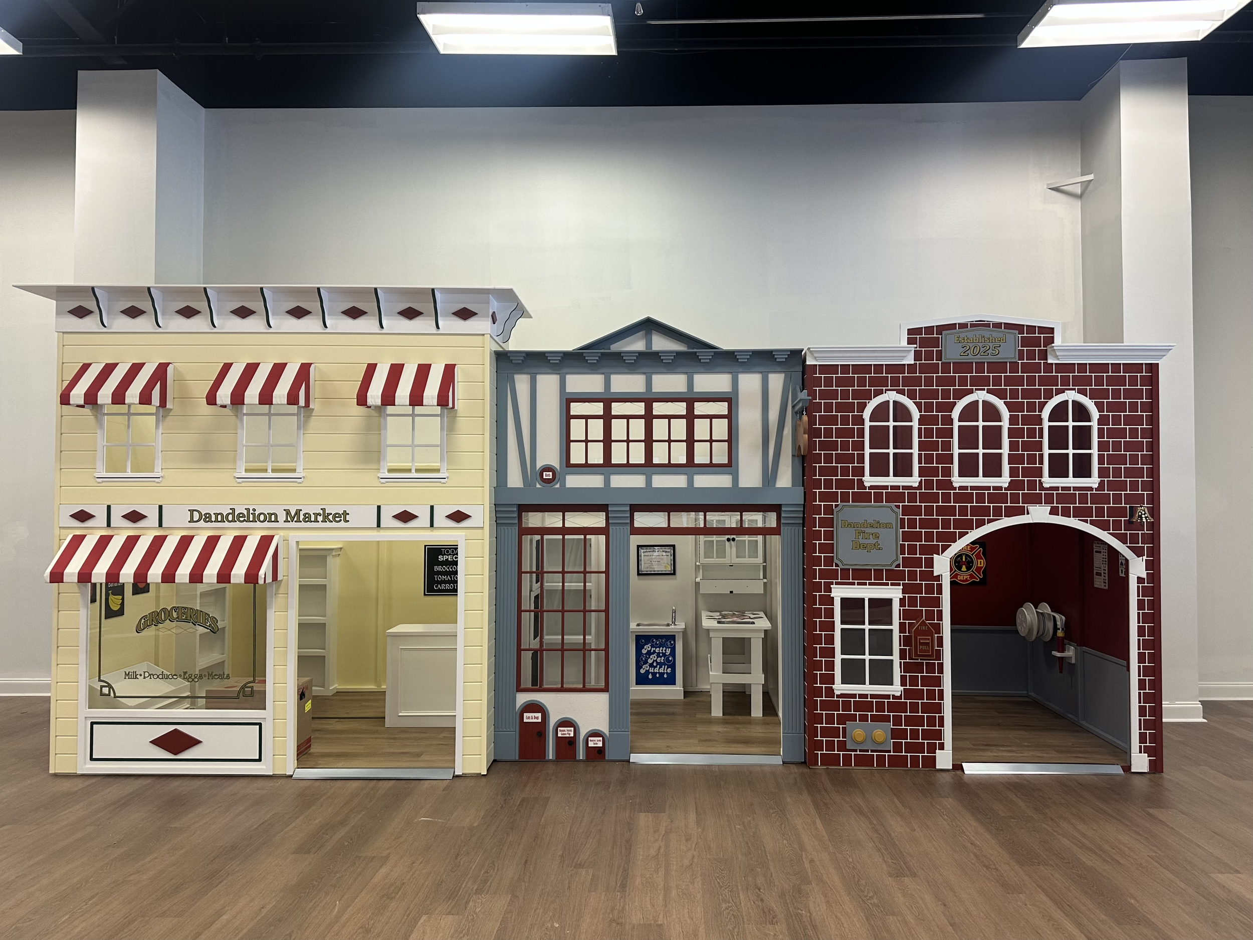 Kid-sized pretend-play storefronts inside Dandelion Play Cafe