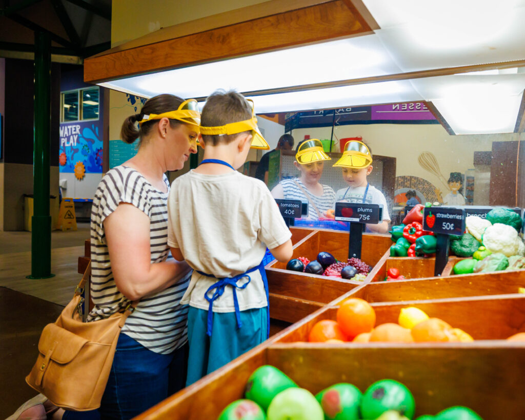 Family in the grocery store exhibit at Discovery Gateway