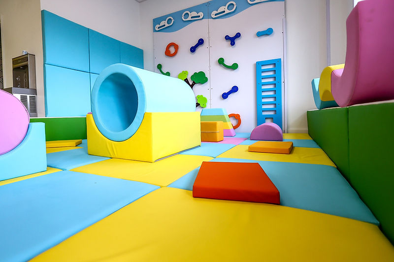 Wide view of the colorful padded soft play area for younger children at Do Play.