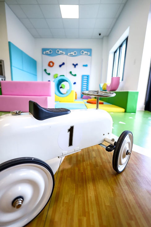 Ride-on toy in the foreground with the under-5 soft play space visible behind it at Do Play.