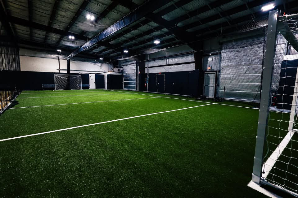 Indoor turf field at Do Play used for sports, camps, and active play.