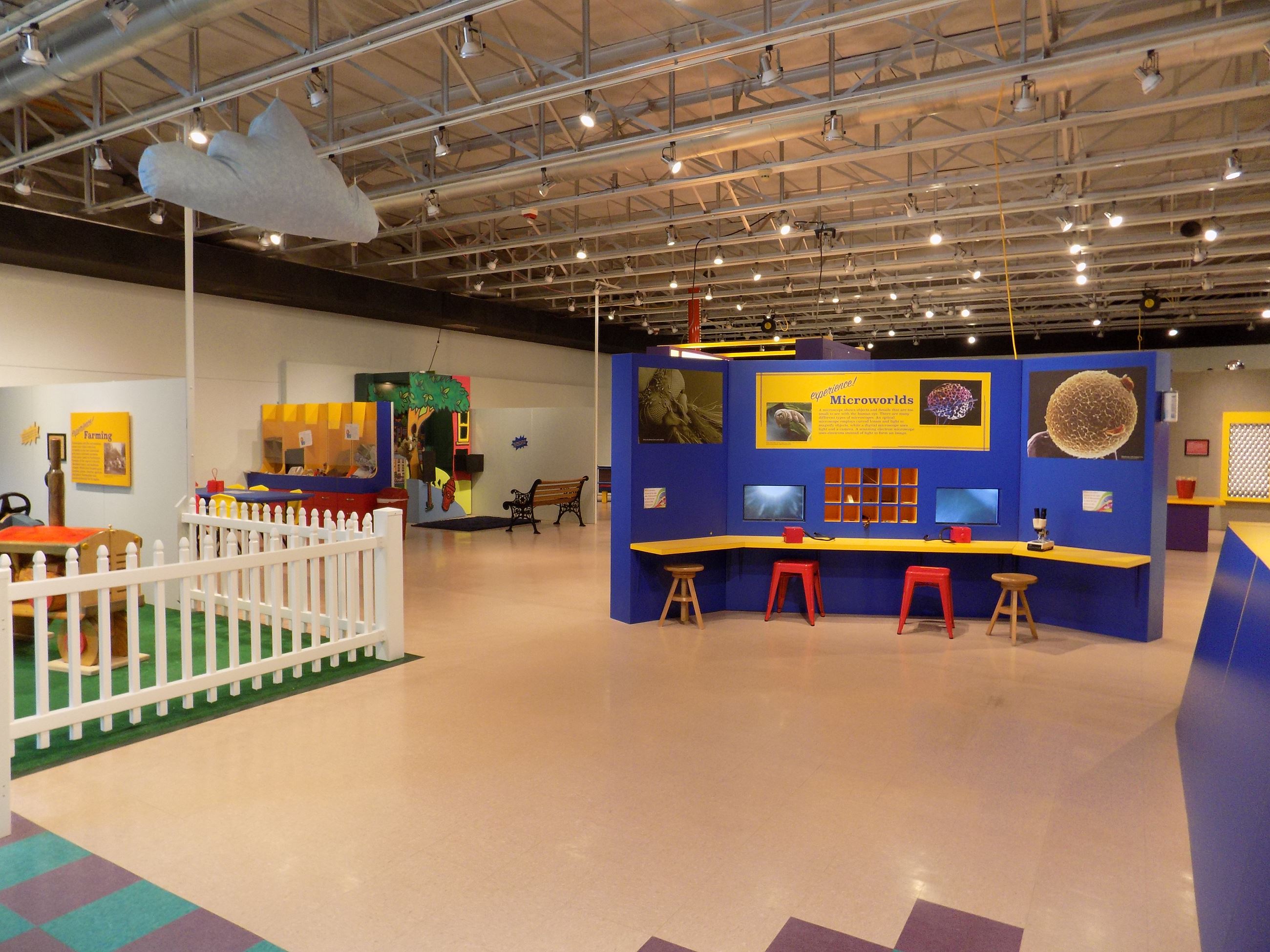 Children exploring exhibit stations inside E3 Children's Museum & Science Center.