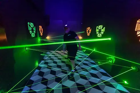 Player navigating green laser beams in the laser vault attraction