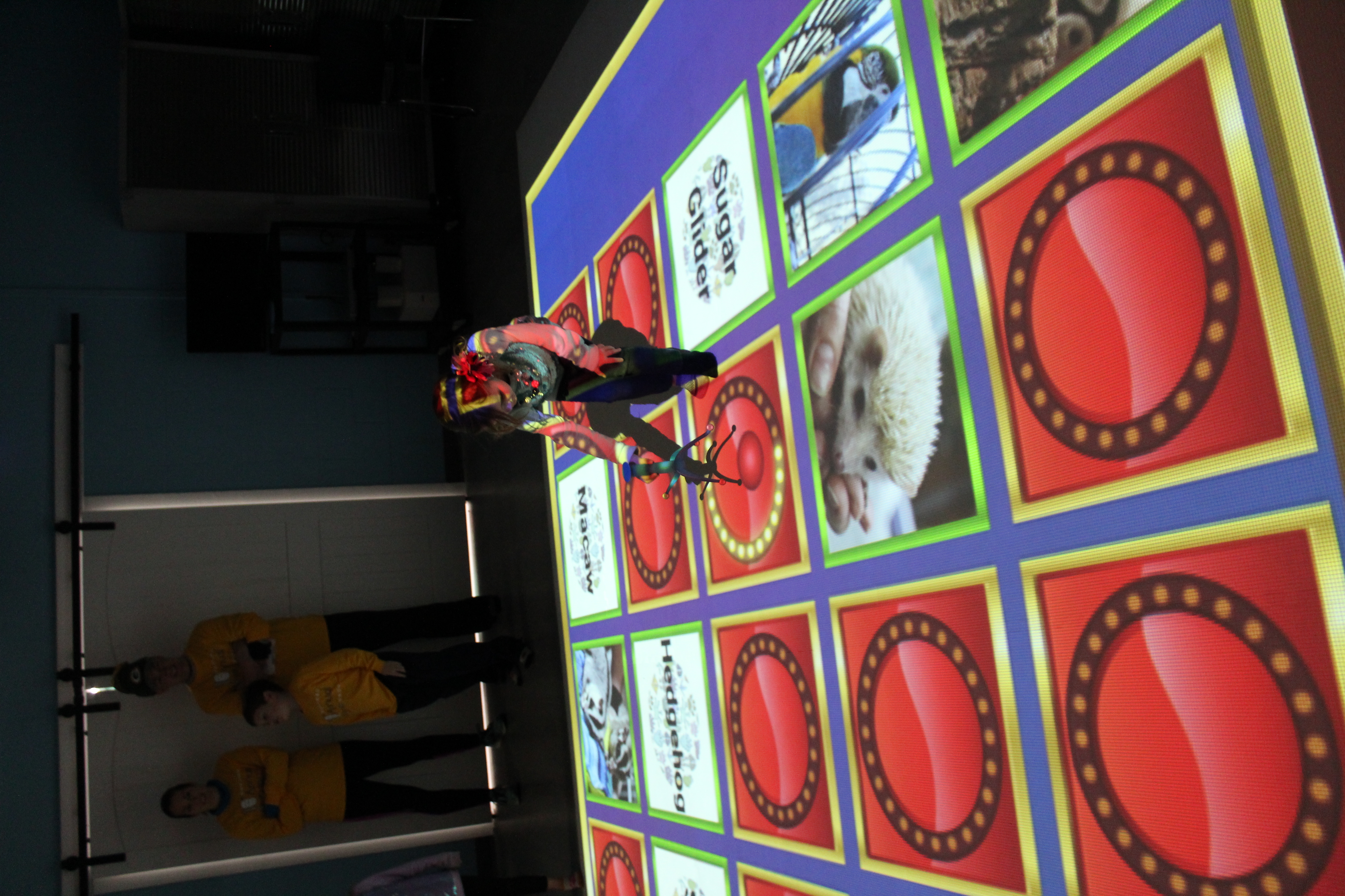 Child using an interactive floor-style exhibit at Emerald Coast Science Center.