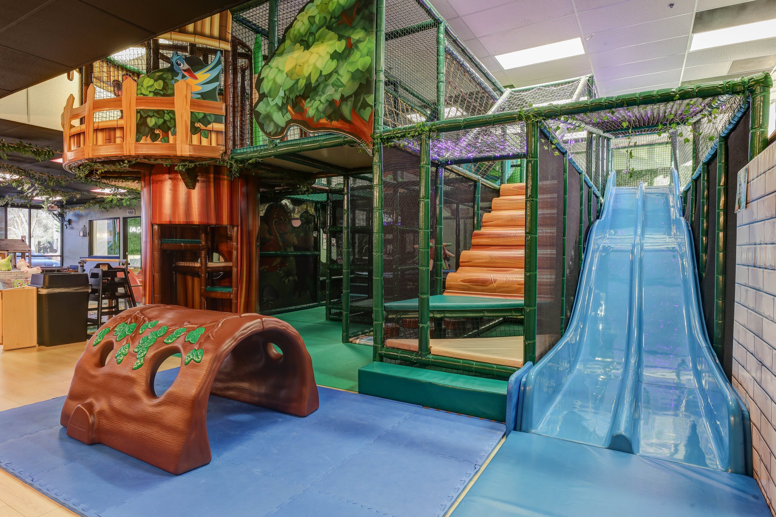 Main indoor play structure with slide and soft crawl feature at Enchanted Elk Grove