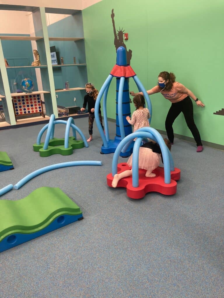 Children using soft climbing and balance elements inside Exceptional Explorers.