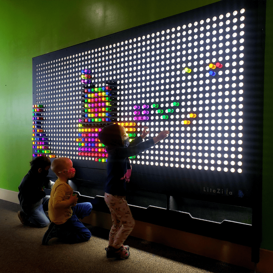 Children creating on the LiteZilla light wall at ExplorationWorks.