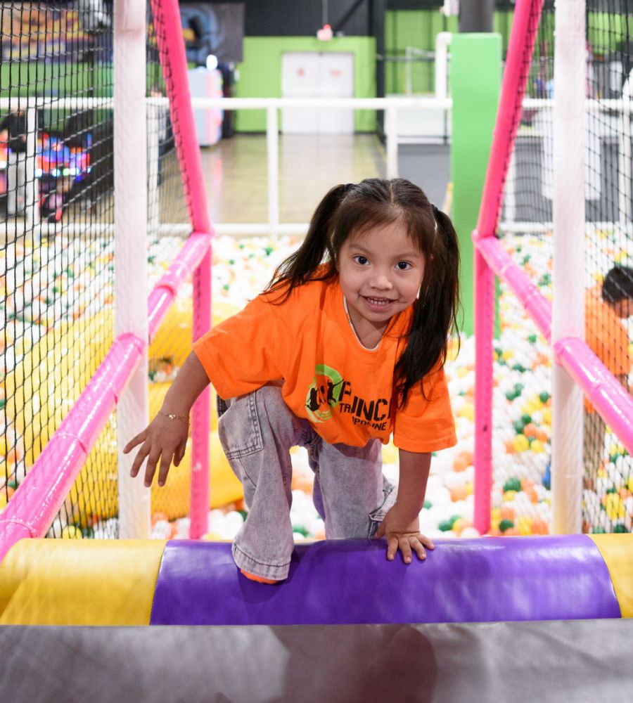 Child crossing into the playground area over a ball pit at Fun City.