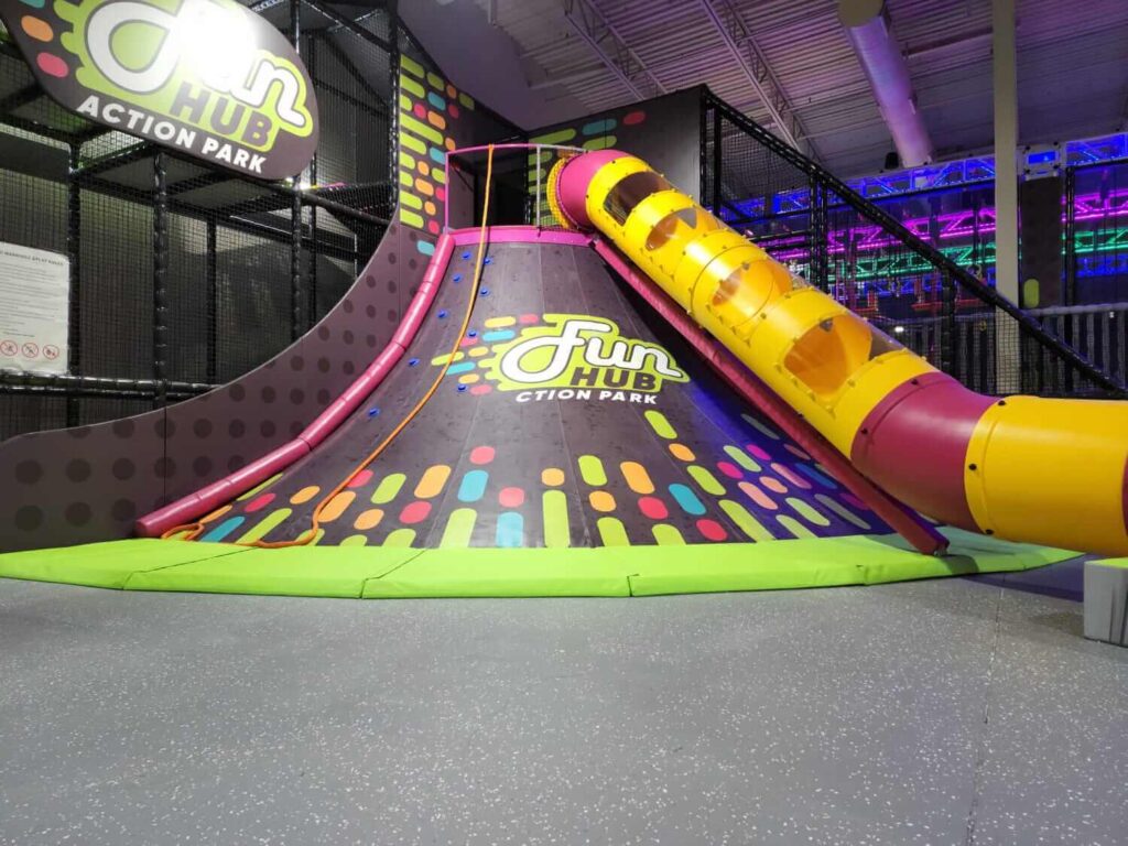 Volcano-style climbing hill and slide feature at FunHub Action Park.