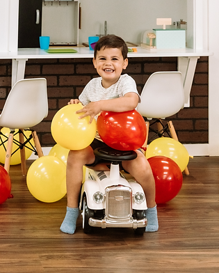 Young child using a ride-on toy at Funtown Play Cafe.