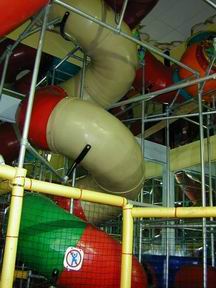 Three-story indoor playground at FunWorld with large tube slides.