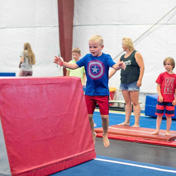 Child balancing on gymnastics mats during open gym at Garland's Gymnastics.