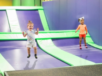 Two smaller children jumping in a kid-focused area at Get Air Tonawanda.